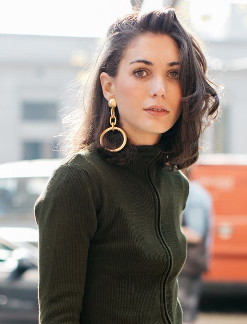 Woman wearing gold hoop earrings during Fashion Week